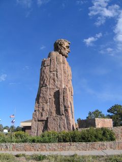 A small bronze plaque is placed at the base of the pedestal and bust, and it indicates that the memorial was provided for by the state of Wyoming.
