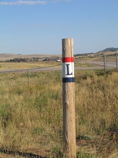 A replica Lincoln Highway trailblazer is painted onto a wooden pole at the Tree in Rock parking area.